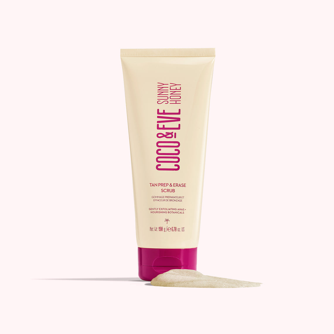 A squeeze tube of CCOO & EVE Sunny Honey Tan Prep & Erase Scrub, featuring a cream-colored body with magenta text and a magenta cap, shown with a smear of the scrub underneath on a pale pink background.